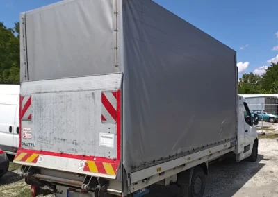 Renault Master ponyvás - hátfalas kisteherautó jobb hátulról fotózva.